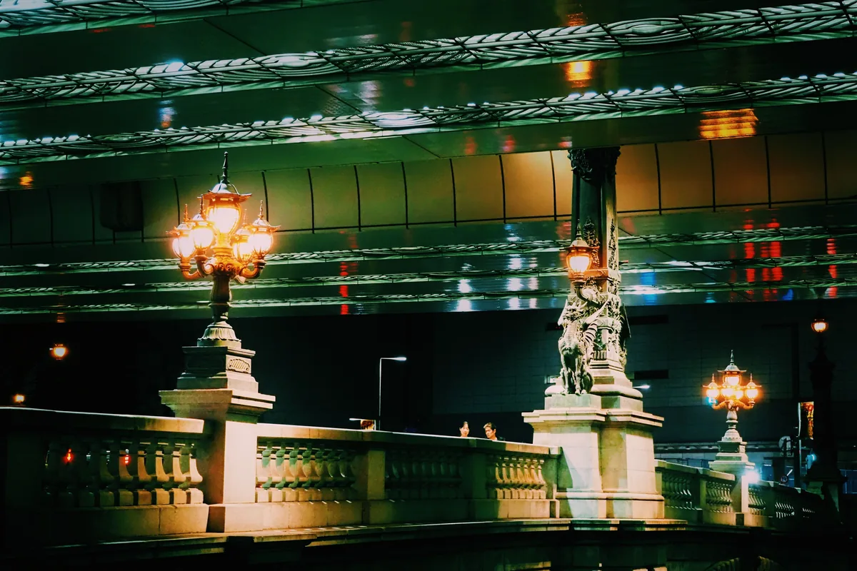 The ornate lamp posts and stone balustrade of Nihonbashi bridge lit at night, Tokyo